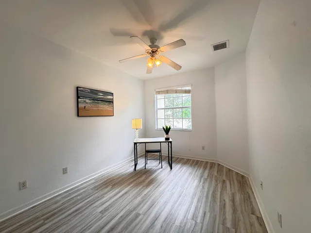 an empty room with a window and a ceiling fan