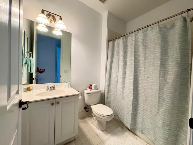 a bathroom with a sink a toilet and shower curtain