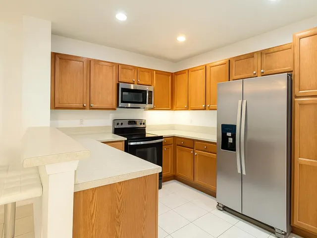a kitchen with granite countertop a refrigerator and a sink