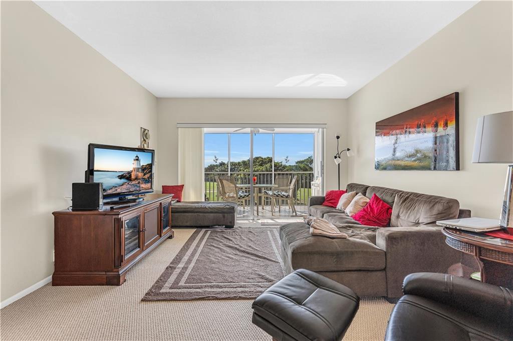 3100 North Palm Aire Drive, Unit 406 Pompano Beach, FL 33069 - Photo 6 of 16 a living room with furniture and a flat screen tv
