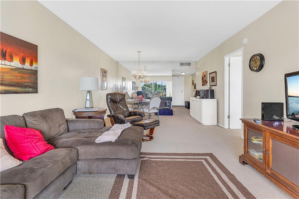 3100 North Palm Aire Drive, Unit 406 Pompano Beach, FL 33069 - Photo 8 of 16 a living room with furniture and a flat screen tv