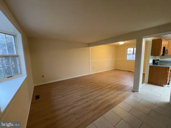 a view of a big room with wooden floor and windows