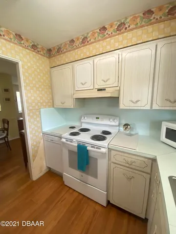a kitchen with white cabinets sink and white appliances