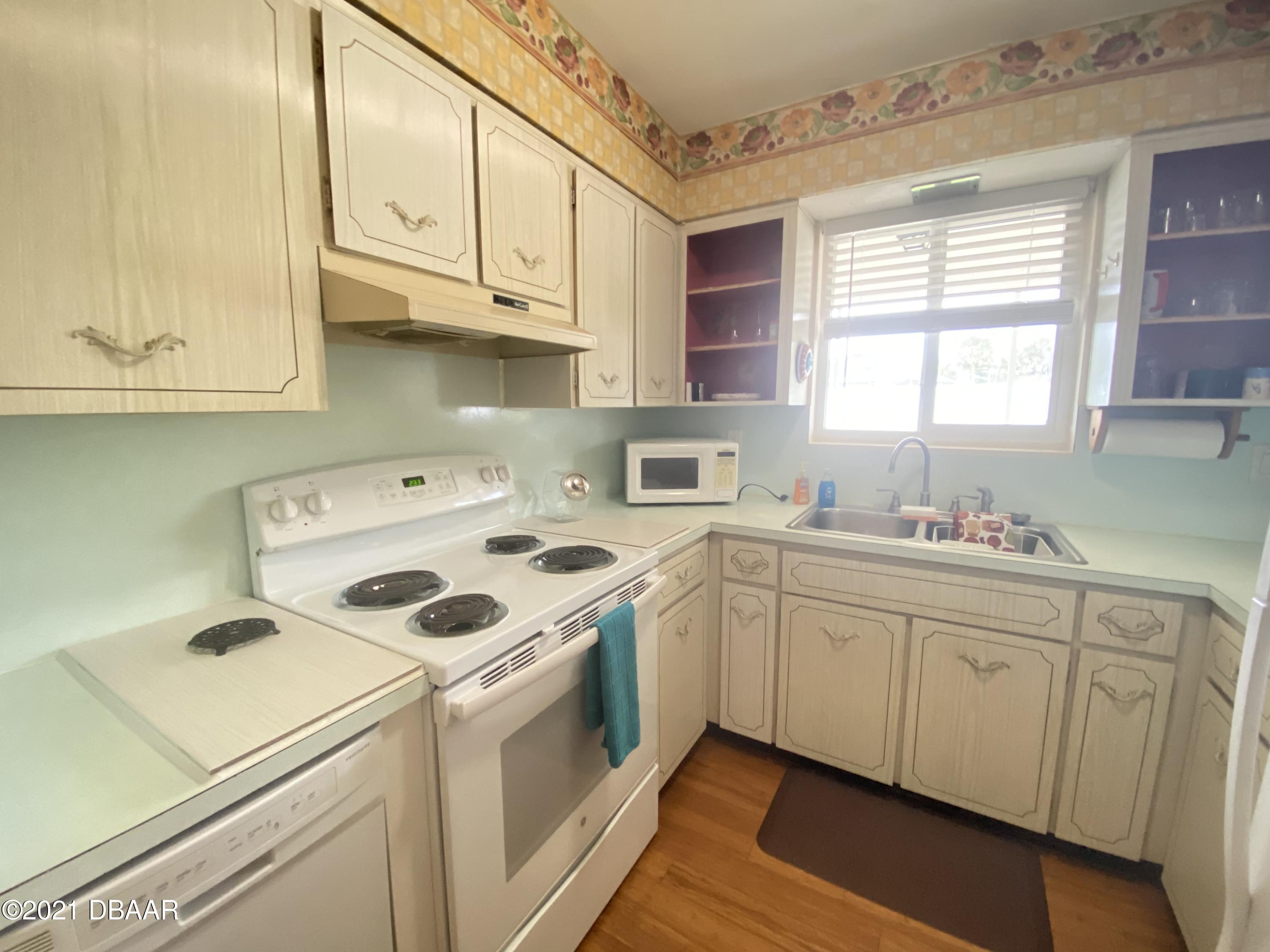 16 Silk Oaks Drive Ormond Beach, FL 32176 - Photo 13 of 37 a kitchen with white cabinets sink and white appliances