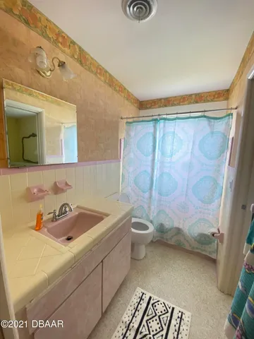 a bathroom with a sink mirror vanity and toilet