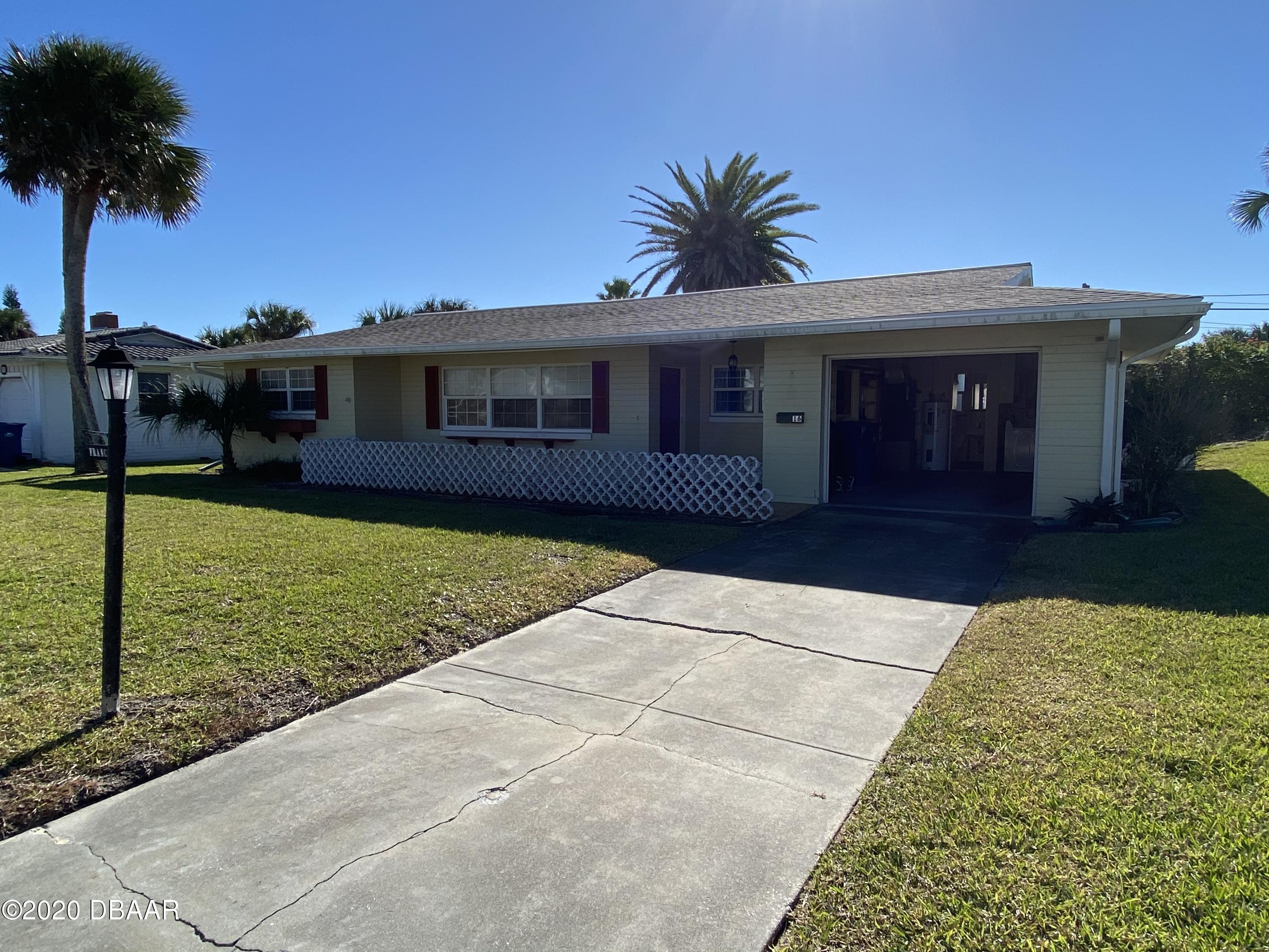 16 Silk Oaks Drive Ormond Beach, FL 32176 - Photo 7 of 37 a front view of a house with a yard and palm trees