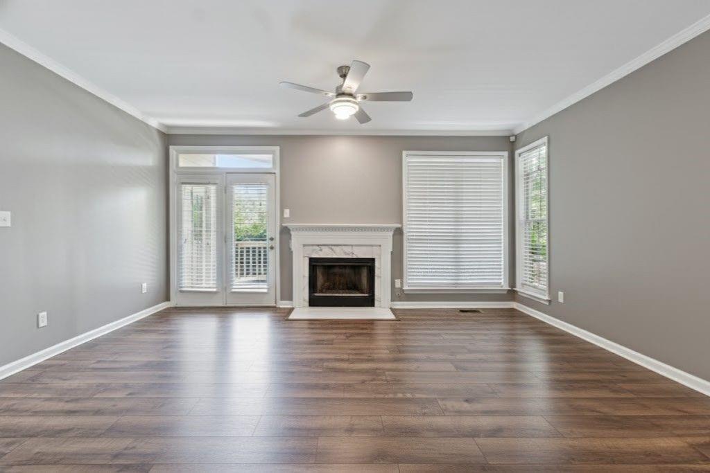 1037 McGill Park Avenue Northeast Atlanta, GA 30312 - Photo 11 of 46 an empty room with wooden floor fireplace and windows
