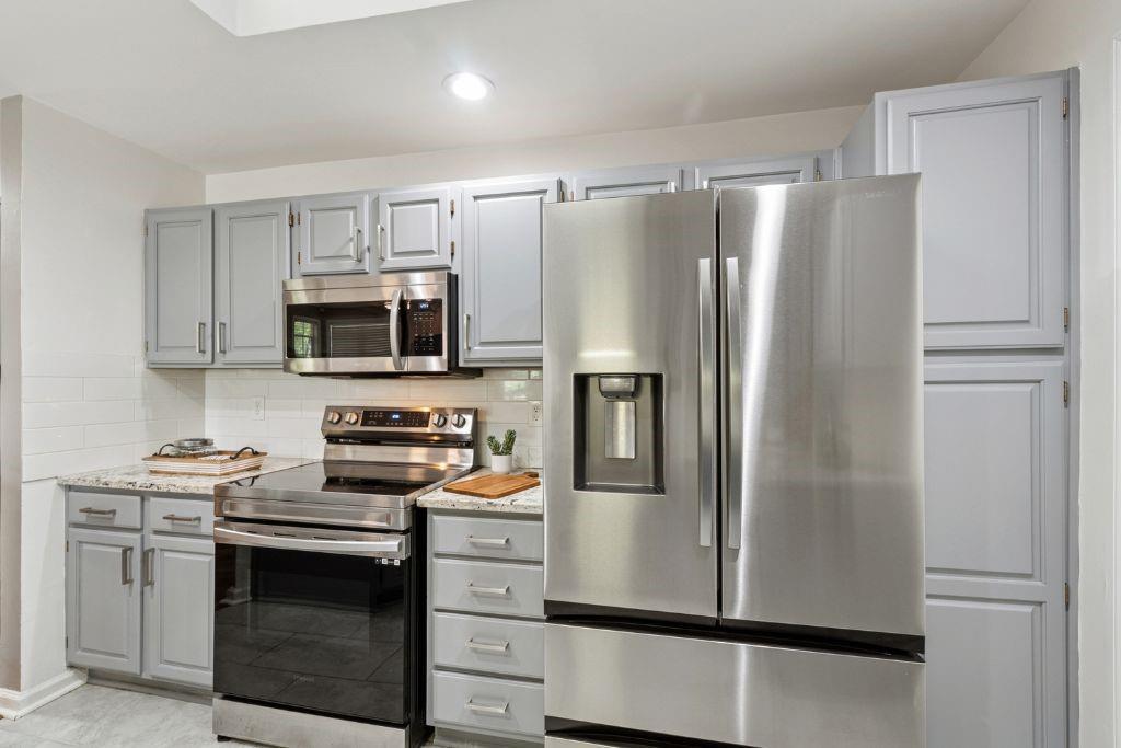1037 McGill Park Avenue Northeast Atlanta, GA 30312 - Photo 20 of 46 a kitchen with stainless steel appliances a refrigerator stove and microwave