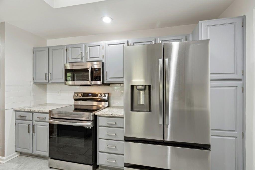 1037 McGill Park Avenue Northeast Atlanta, GA 30312 - Photo 21 of 46 a kitchen with stainless steel appliances a refrigerator stove and microwave
