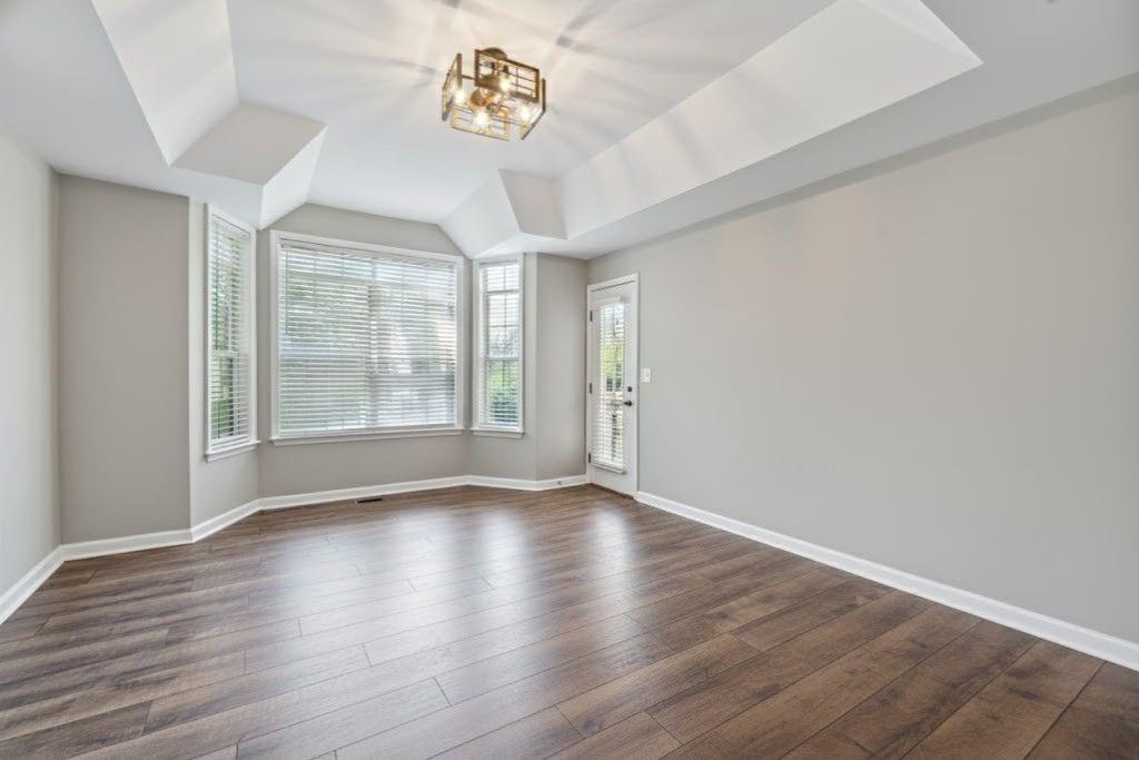 1037 McGill Park Avenue Northeast Atlanta, GA 30312 - Photo 22 of 46 a view of an empty room with a window and wooden floor
