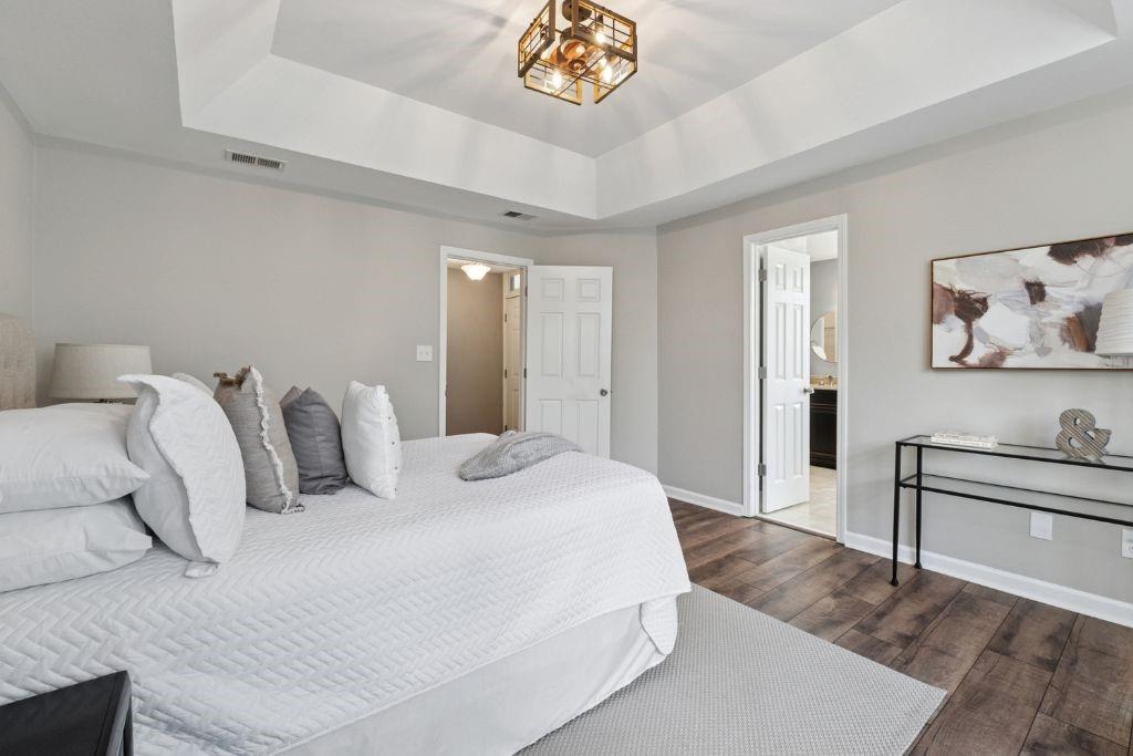 1037 McGill Park Avenue Northeast Atlanta, GA 30312 - Photo 23 of 46 a bedroom with a bed and a lamp on dresser