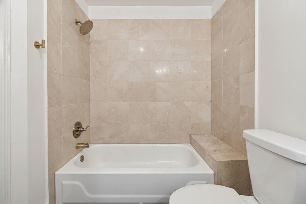 1037 McGill Park Avenue Northeast Atlanta, GA 30312 - Photo 32 of 46 a white bath tub sitting next to a white toilet and sink