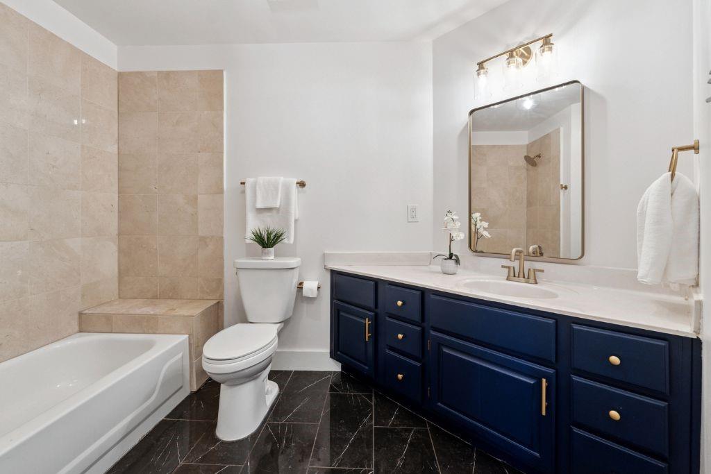 1037 McGill Park Avenue Northeast Atlanta, GA 30312 - Photo 33 of 46 a bathroom with a bathtub shower sink vanity mirror and toilet