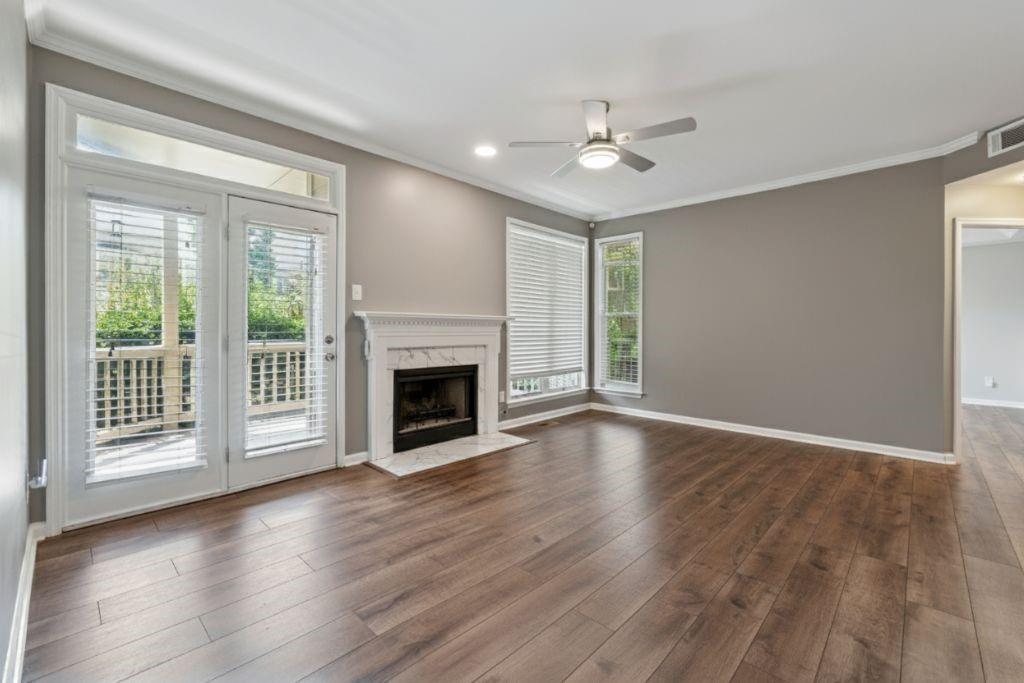 1037 McGill Park Avenue Northeast Atlanta, GA 30312 - Photo 8 of 46 a view of an empty room with wooden floor fireplace and a window