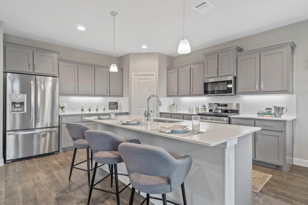 105 Ringtail Drive Rhome, TX 76078 - Photo 38 of 40 a kitchen with kitchen island granite countertop a center island a sink stainless steel appliances and cabinets