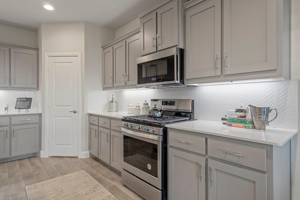 105 Ringtail Drive Rhome, TX 76078 - Photo 4 of 40 a kitchen with white cabinets and stainless steel appliances