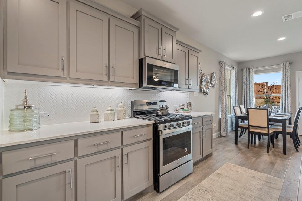 105 Ringtail Drive Rhome, TX 76078 - Photo 8 of 40 a kitchen with white cabinets and white appliances