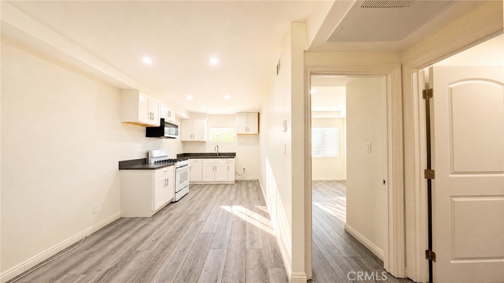 6851 Foothill Boulevard Tujunga, CA 91042 - Photo 35 of 50 a kitchen with white cabinets and wooden floor