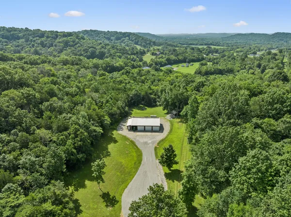 an aerial view of a house with a yard and lake view