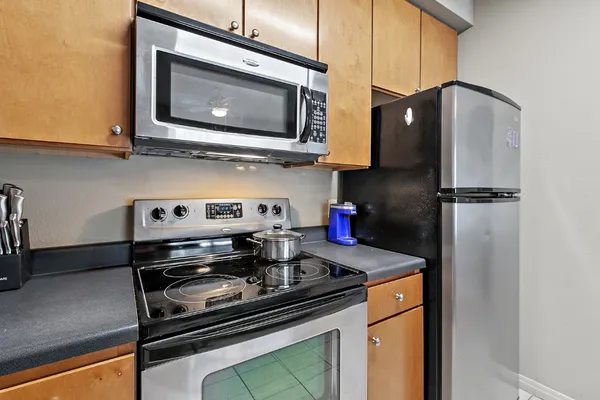 a kitchen with stainless steel appliances granite countertop a stove microwave and refrigerator