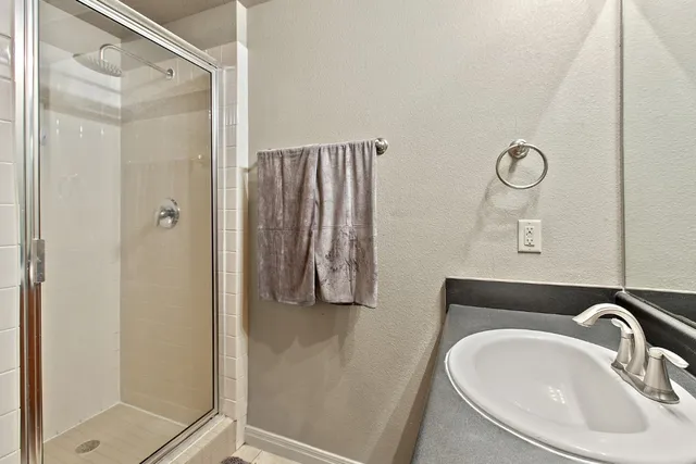 a bathroom with a sink a mirror and shower