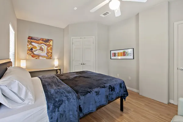 a bedroom with a bed and a painting on the wall