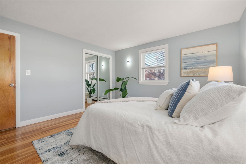 32 Whitman Road, Unit 14 Waltham, MA 02453 - Photo 11 of 20 a bedroom with a bed and wooden floor