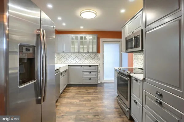a kitchen with stainless steel appliances granite countertop a refrigerator and a stove