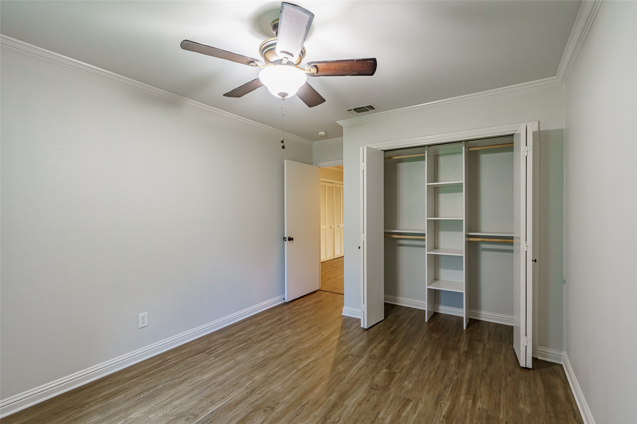 8810 Mountain Path Circle Austin, TX 78759 - Photo 13 of 37 Unfurnished bedroom featuring dark wood-style flooring, crown molding, a closet, and ceiling fan