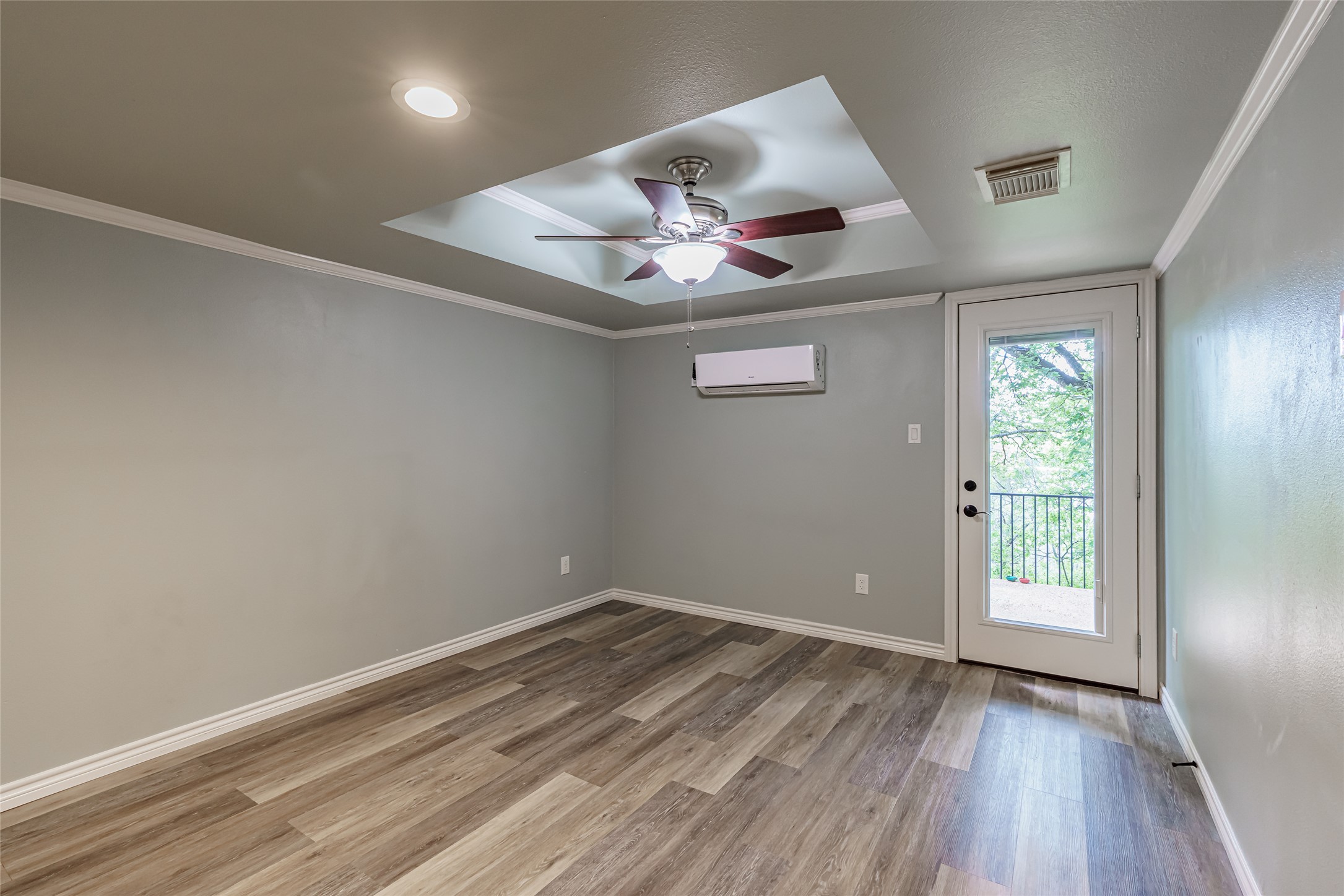 8810 Mountain Path Circle Austin, TX 78759 - Photo 21 of 37 Entryway featuring a raised ceiling, wood finished floors, crown molding, ceiling fan, and a wall mounted AC