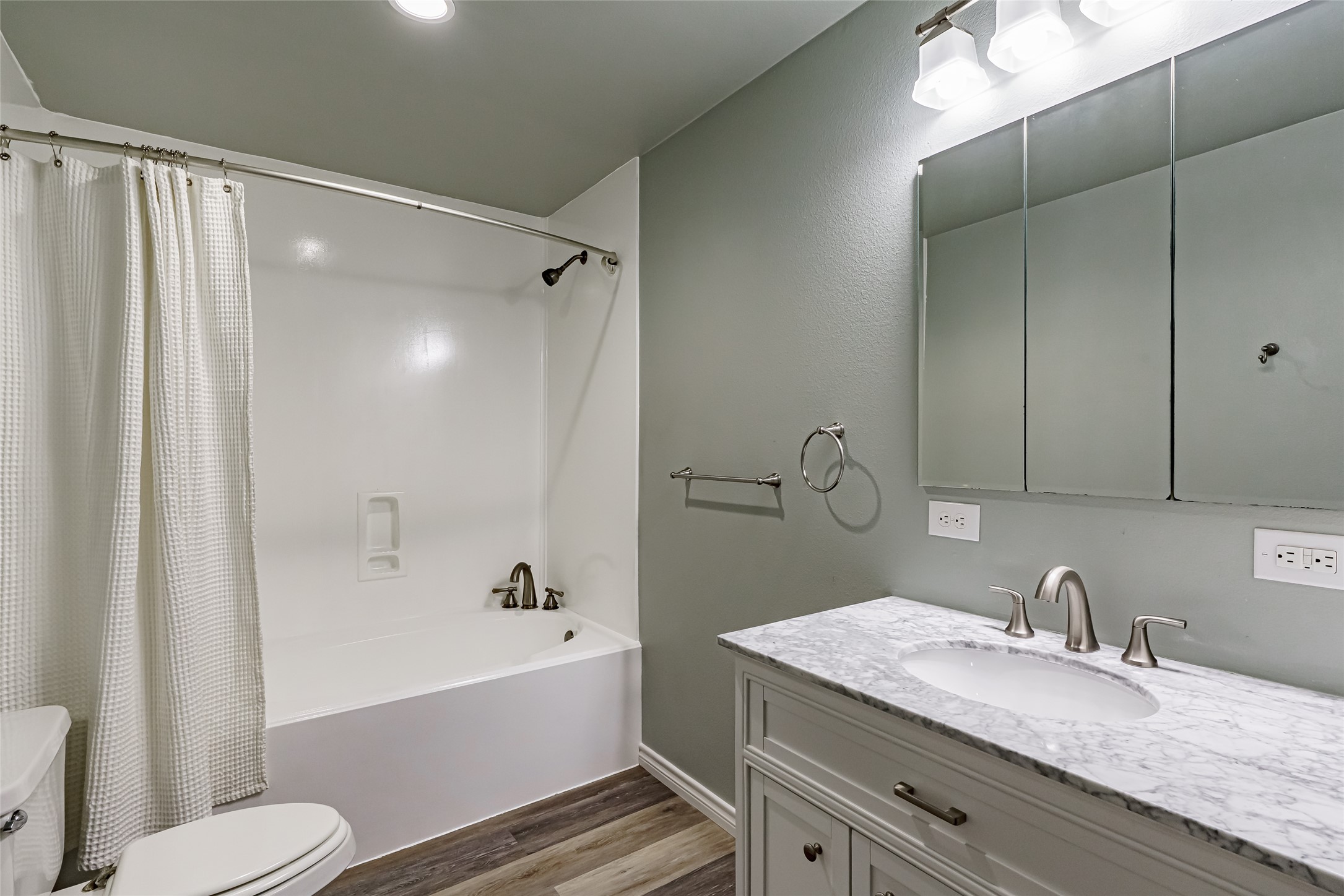 8810 Mountain Path Circle Austin, TX 78759 - Photo 23 of 37 Bathroom featuring vanity, shower / bath combo with shower curtain, and dark wood-type flooring
