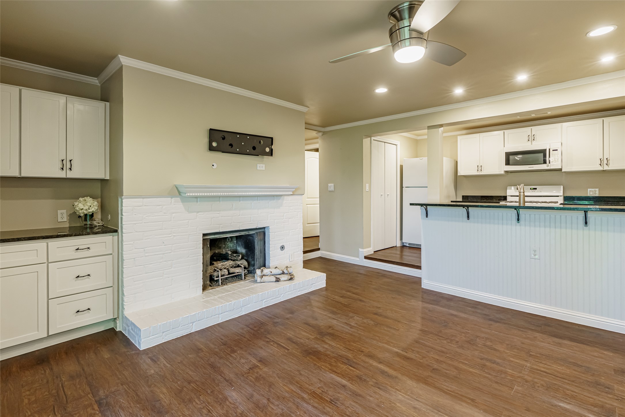 8810 Mountain Path Circle Austin, TX 78759 - Photo 24 of 37 Kitchen featuring white cabinets, white appliances, dark wood finished floors, ornamental molding, and a ceiling fan