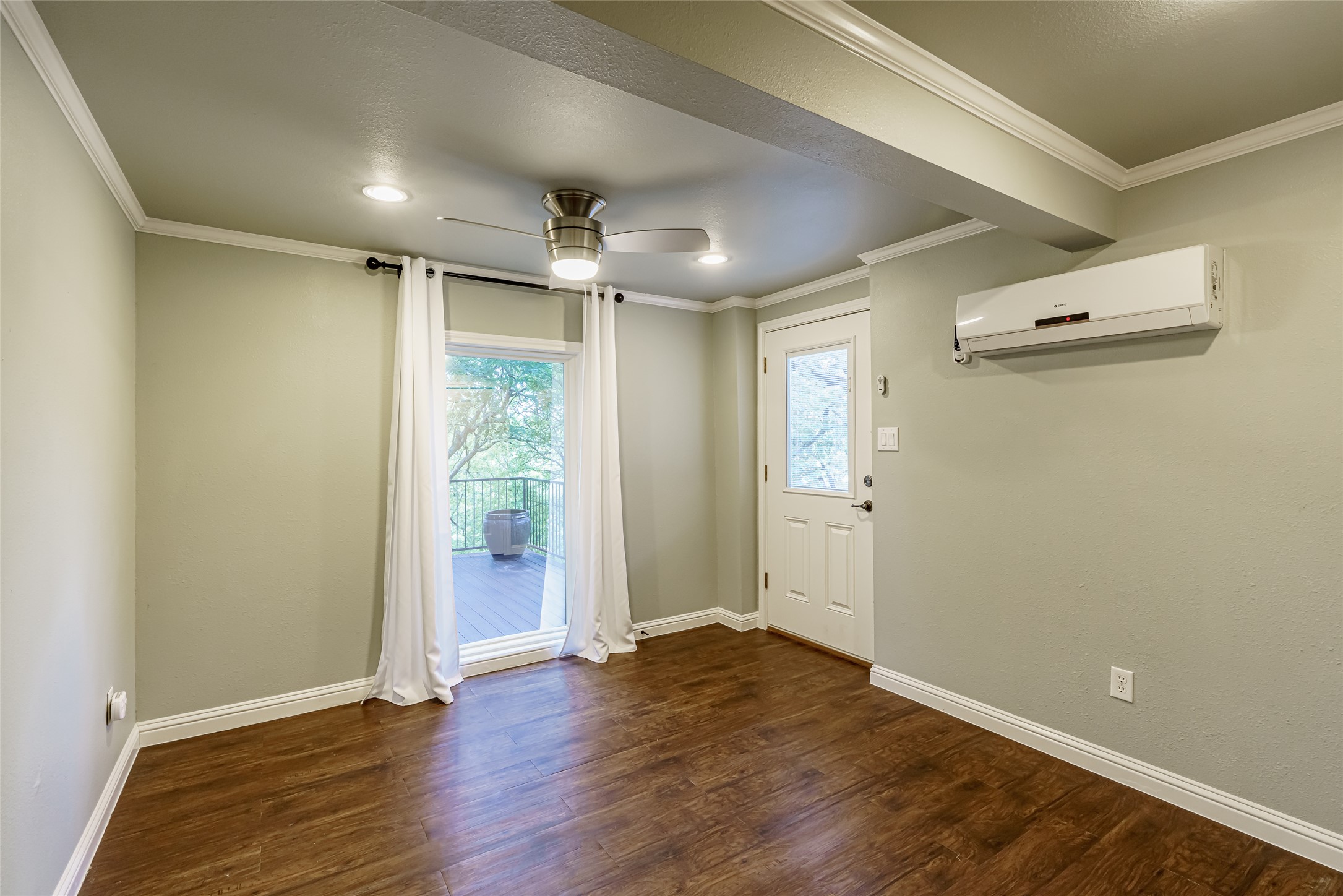 8810 Mountain Path Circle Austin, TX 78759 - Photo 26 of 37 Doorway featuring crown molding, wood finished floors, a ceiling fan, and a wall unit AC
