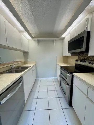 a kitchen with a stove a sink and a microwave