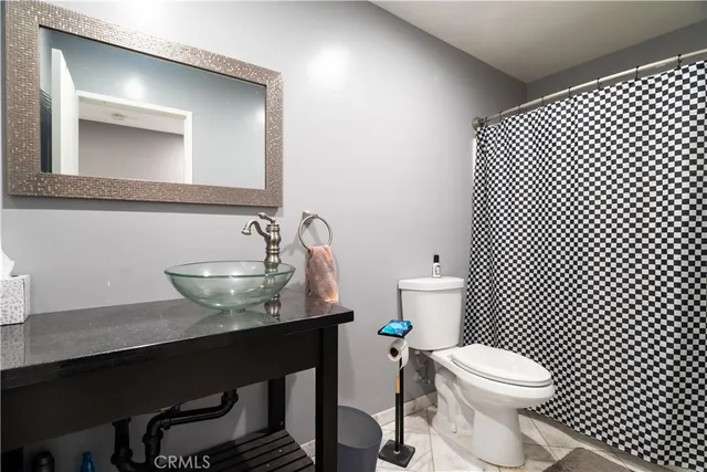 a kitchen with stainless steel appliances kitchen island granite countertop a refrigerator a stove a sink dishwasher and white cabinets with wooden floor