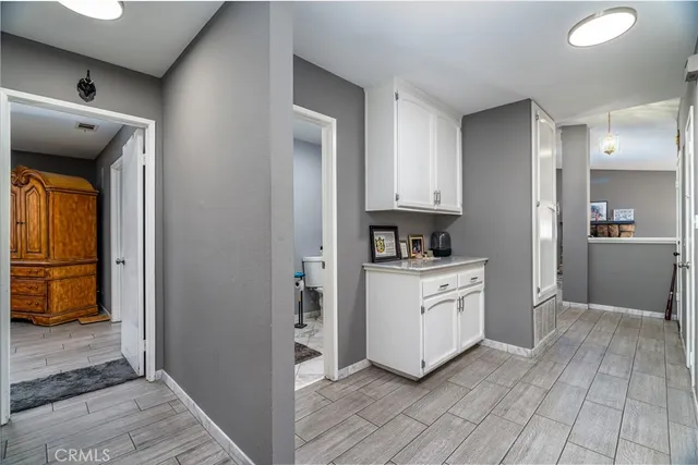 a kitchen with stainless steel appliances kitchen island granite countertop a refrigerator a stove and a dining table with wooden floor