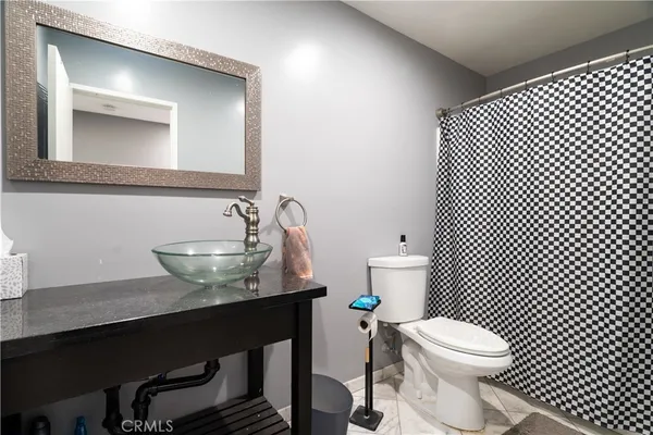 a bathroom with a sink a toilet a mirror and shower