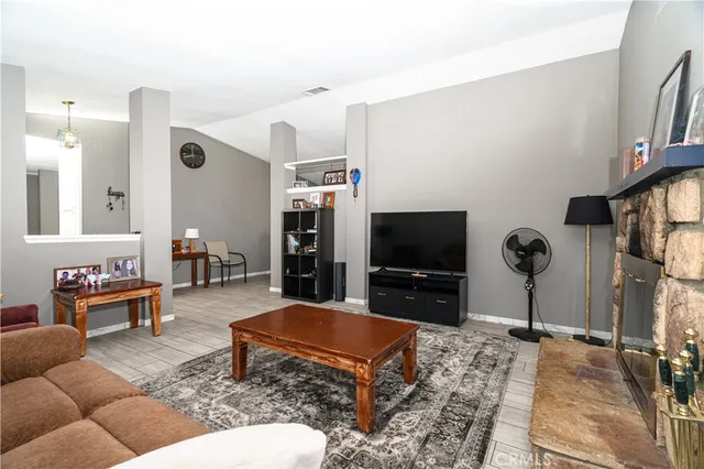 a living room with furniture a fireplace and a flat screen tv