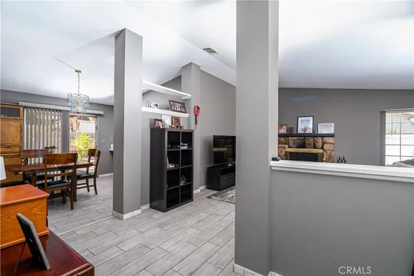 a kitchen with stainless steel appliances kitchen island granite countertop a refrigerator a stove and a dining table with wooden floor