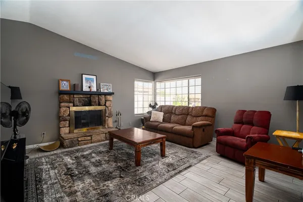 a living room with furniture a flat screen tv and a window