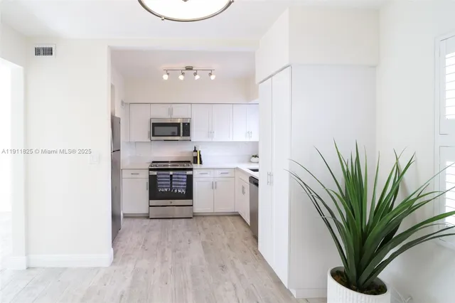 a kitchen with a refrigerator and a stove top oven