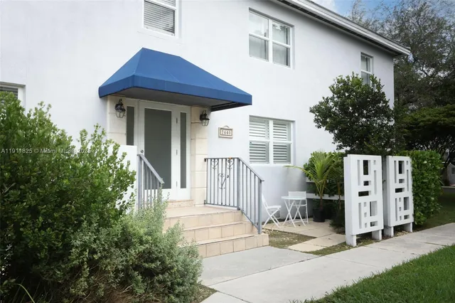 a view of a house with a small yard and plants