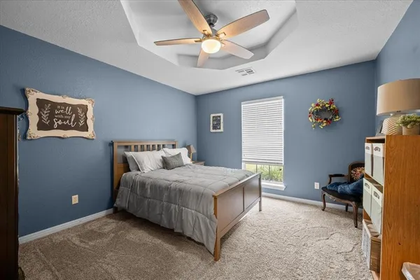 a bedroom with a bed window and a chandelier