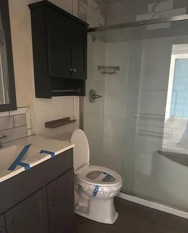 a bathroom with a toilet a sink and mirror
