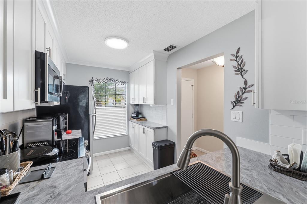1804 Rising Sun Drive, Unit 1804 Holiday, FL 34690 - Photo 12 of 31 a kitchen with a refrigerator and a stove top oven