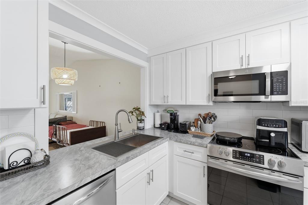 1804 Rising Sun Drive, Unit 1804 Holiday, FL 34690 - Photo 14 of 31 a kitchen with stainless steel appliances granite countertop a sink stove and cabinets