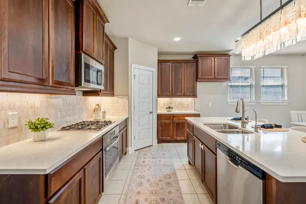 a kitchen with stainless steel appliances granite countertop a sink stove and cabinets