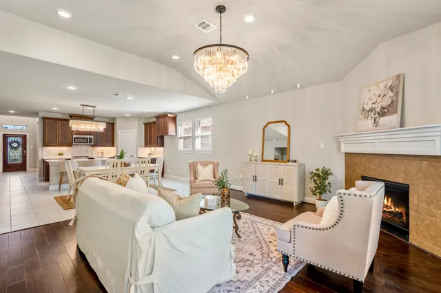 a living room with furniture a fireplace and wooden floor
