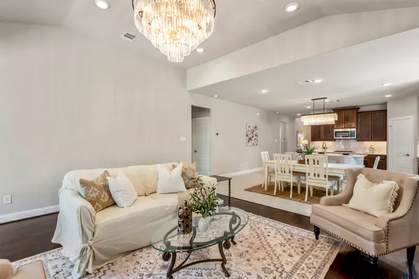 a living room with furniture and a chandelier