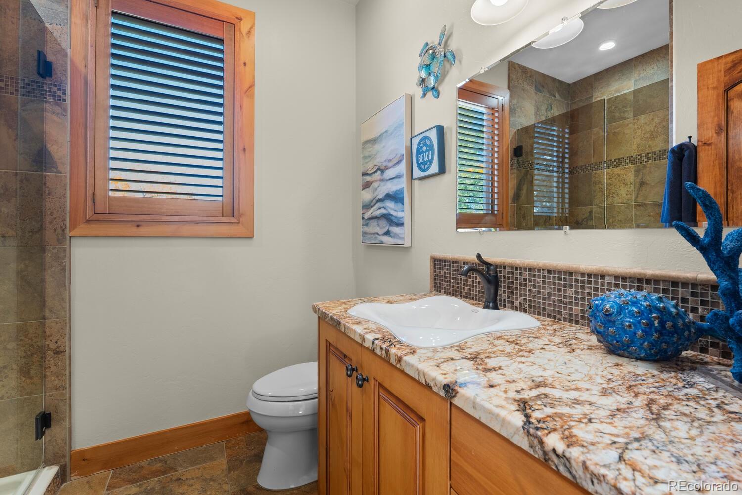 60075 Oak Grove Road Montrose, CO 81403 - Photo 21 of 50 a bathroom with a granite countertop sink and a toilet
